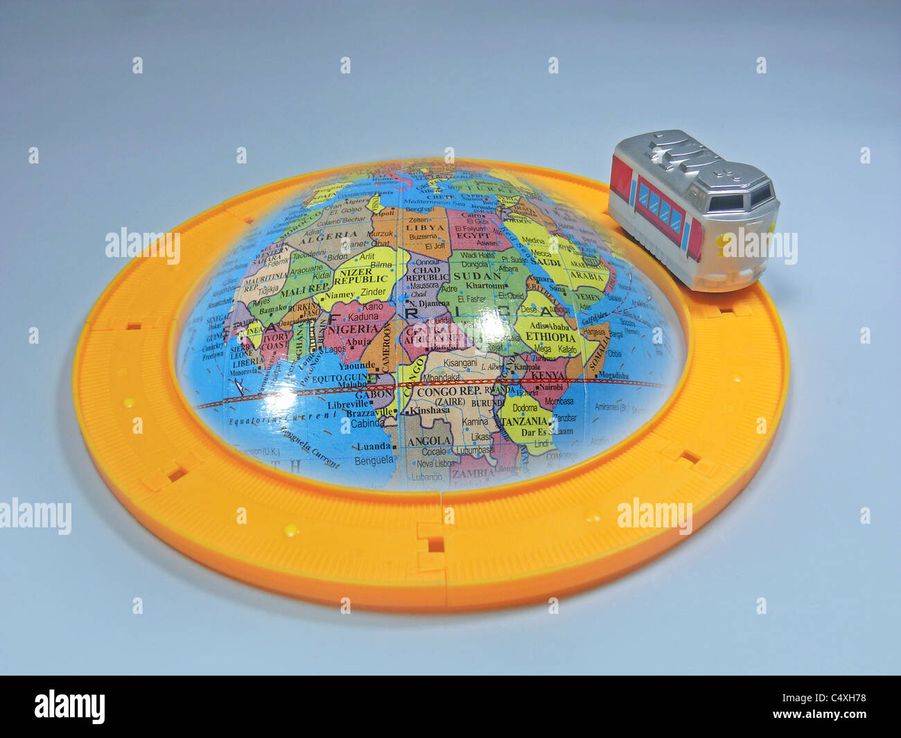 Toy train around model of planet Earth, Concept Stock Photo