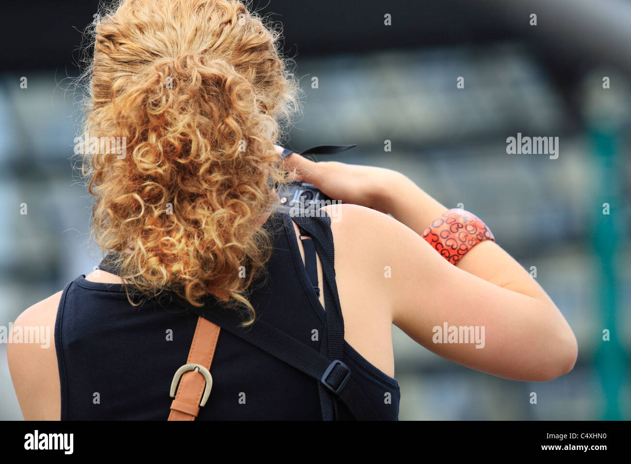 Rear view of a young woman taking picture in the city Stock Photo - Alamy