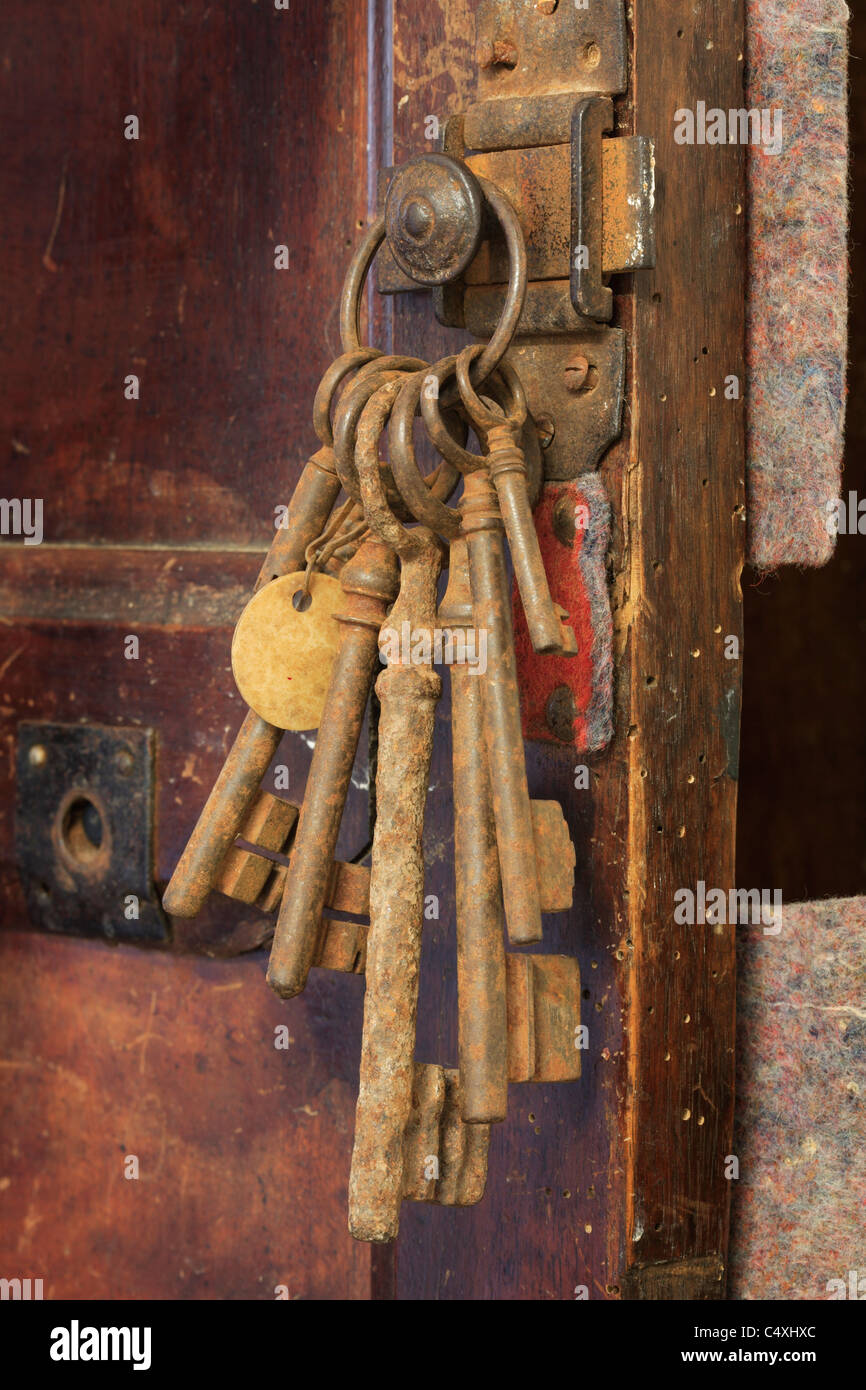Bunch of old keys hanging from a door. Stock Photo