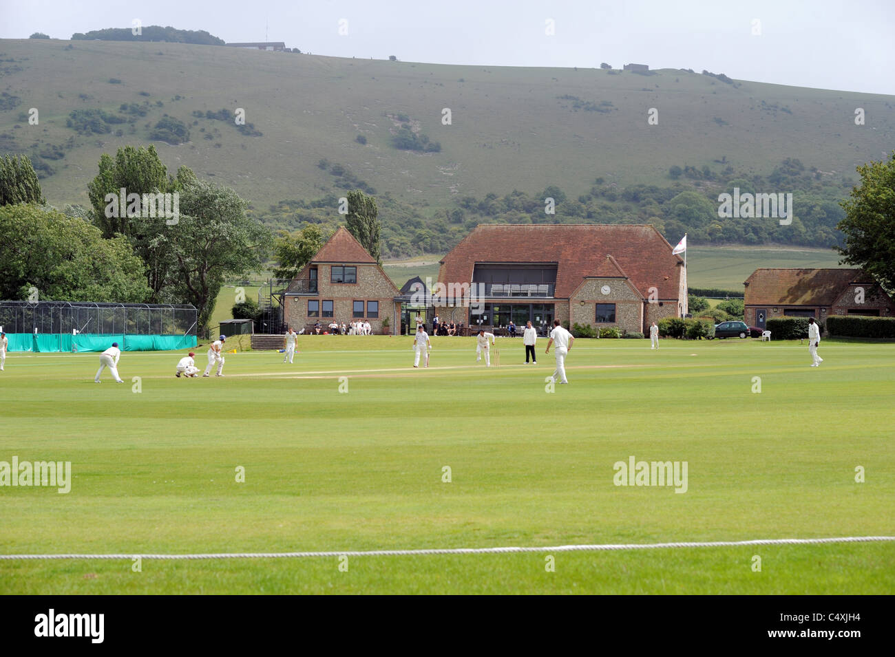 Preston Nomads play hosts to Horsham cricket team at their picturesque ground in Fulking Sussex which is overlooked by the Downs Stock Photo