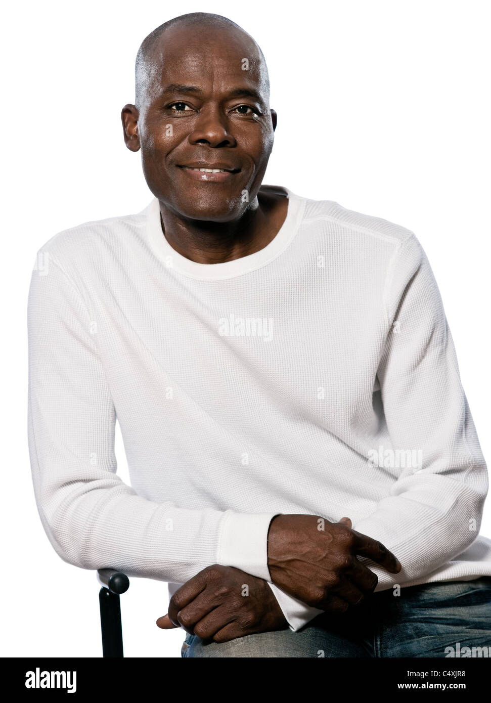 Portrait of a casual handsome afro American man smiling while sitting in studio on white isolated background Stock Photo