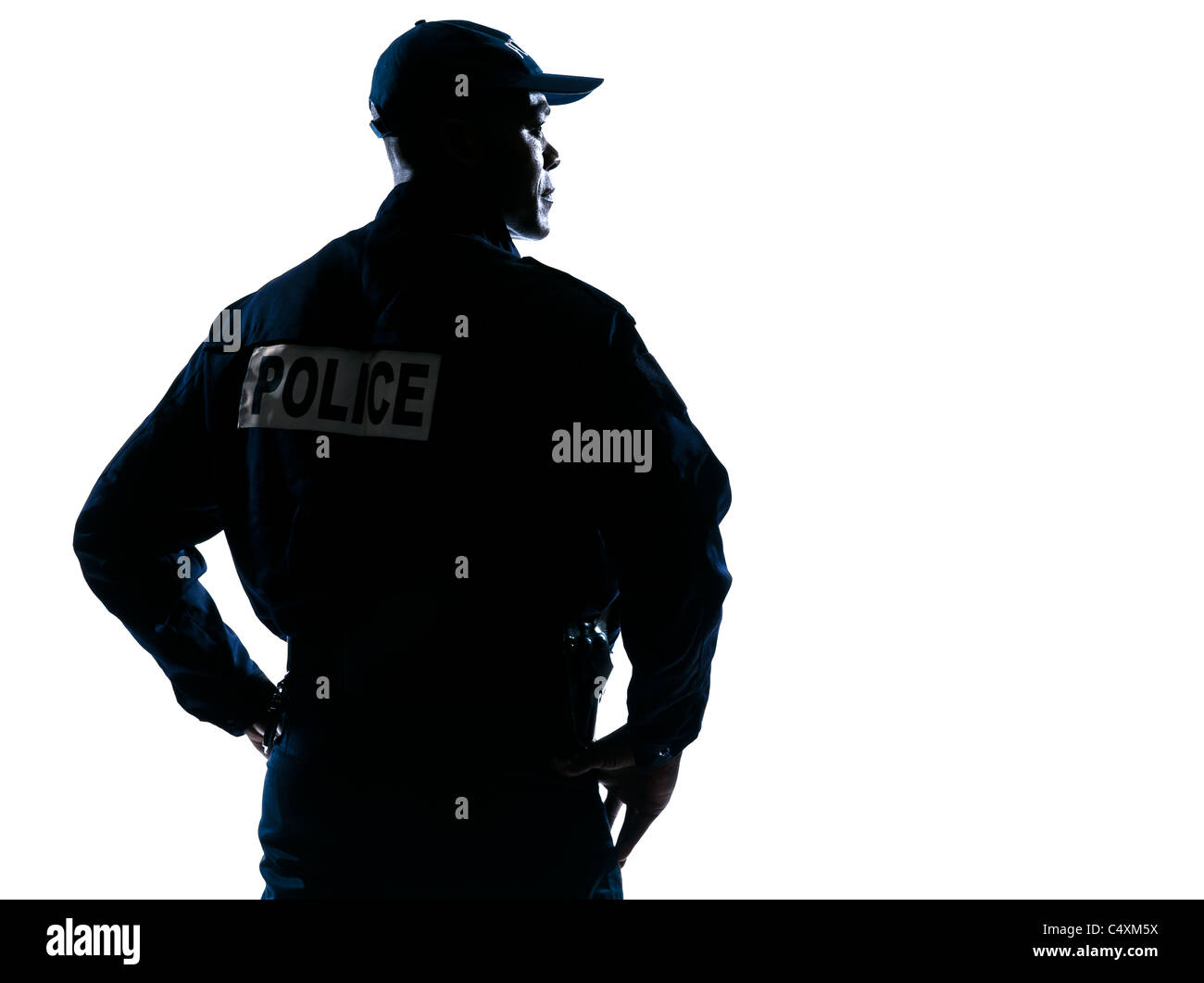 Rear view of a serious afro American policeman with hands on hip looking to his side on white isolated background Stock Photo