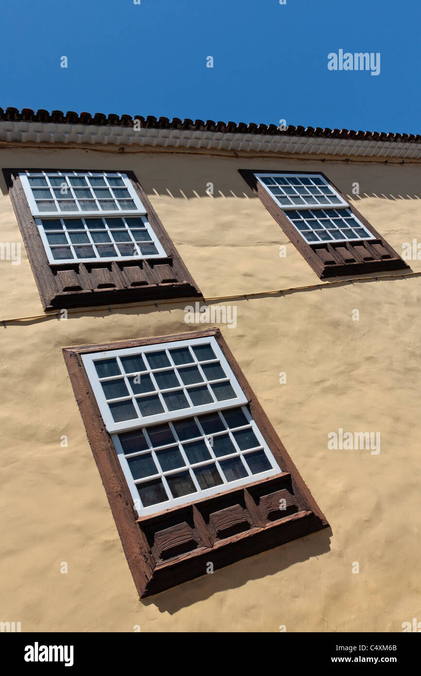 Three windows and a roofline on one of the buildings in La Laguna a world heritage site Tenerife Canary Islands Spain Stock Photo