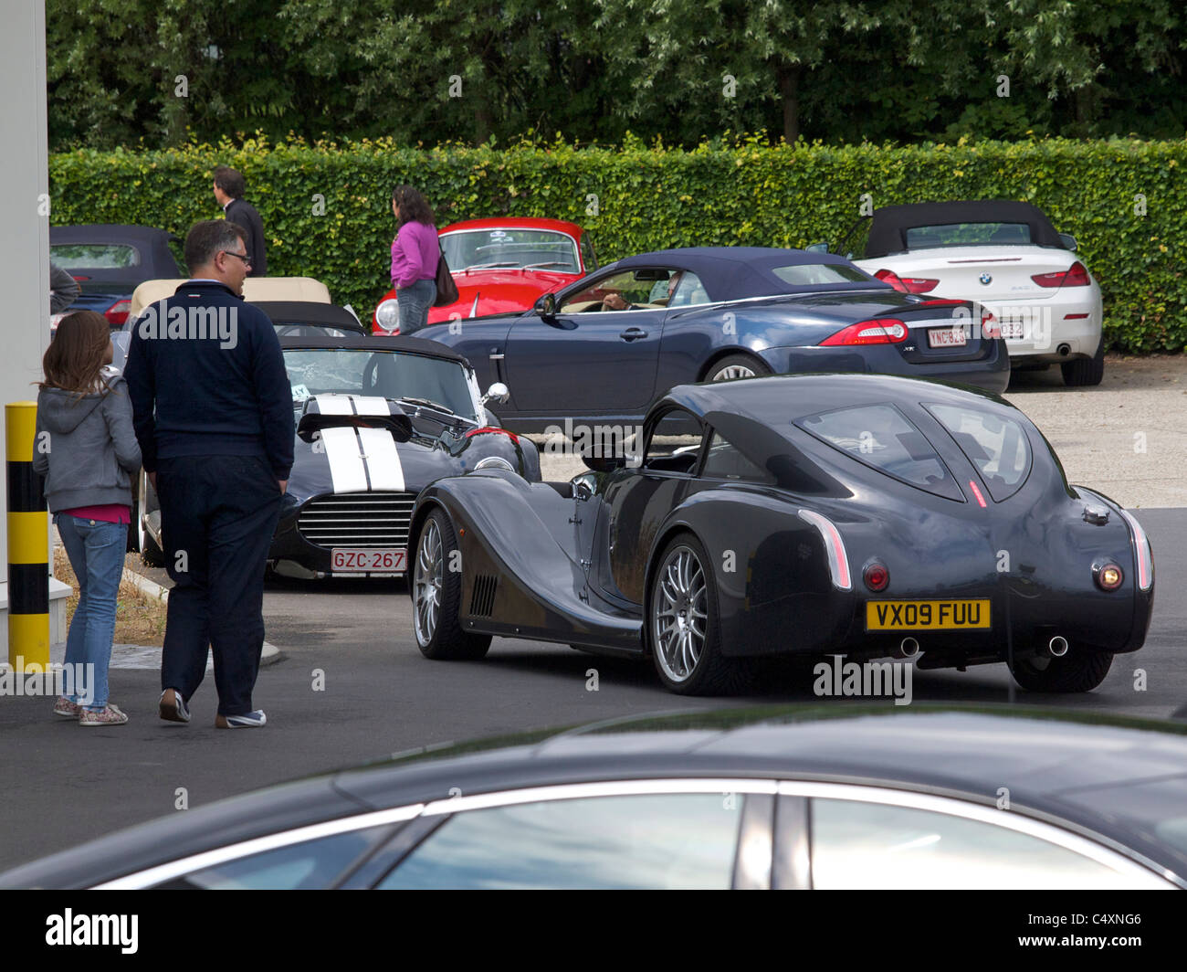 People looking at cars in the parkinglot during a classic car rallye in Belgium Stock Photo