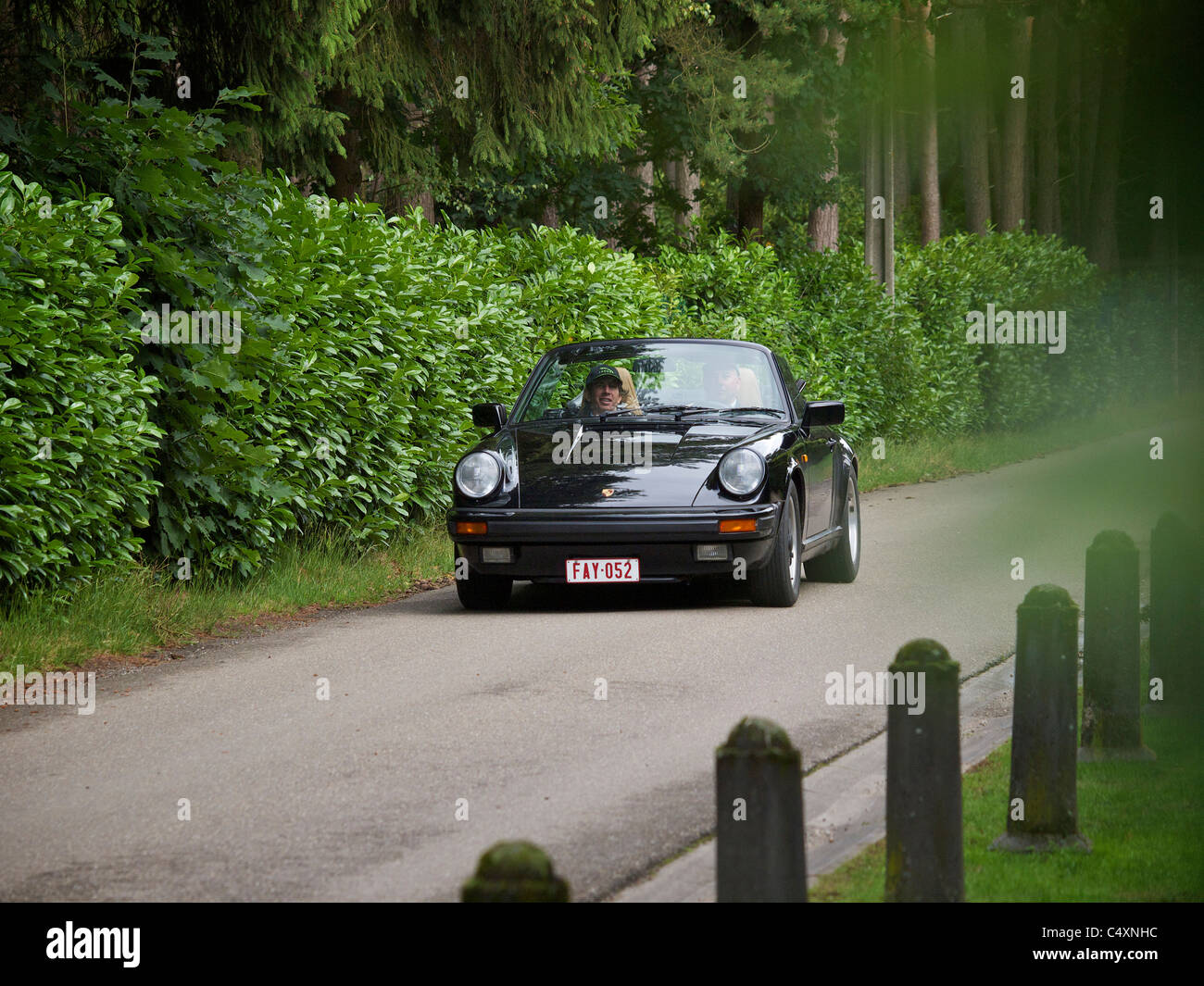 Black classic Porsche 911 convertible driving on a country lane in Oud Turnhout, Belgium Stock Photo