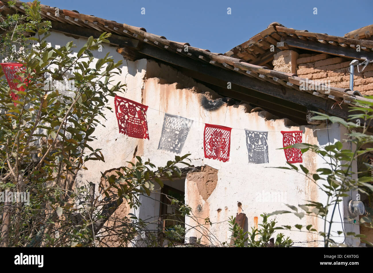 A decorative picado banner hangs outside a residence in charming San Sebastian del Oeste in Jalisco, Mexico. Stock Photo