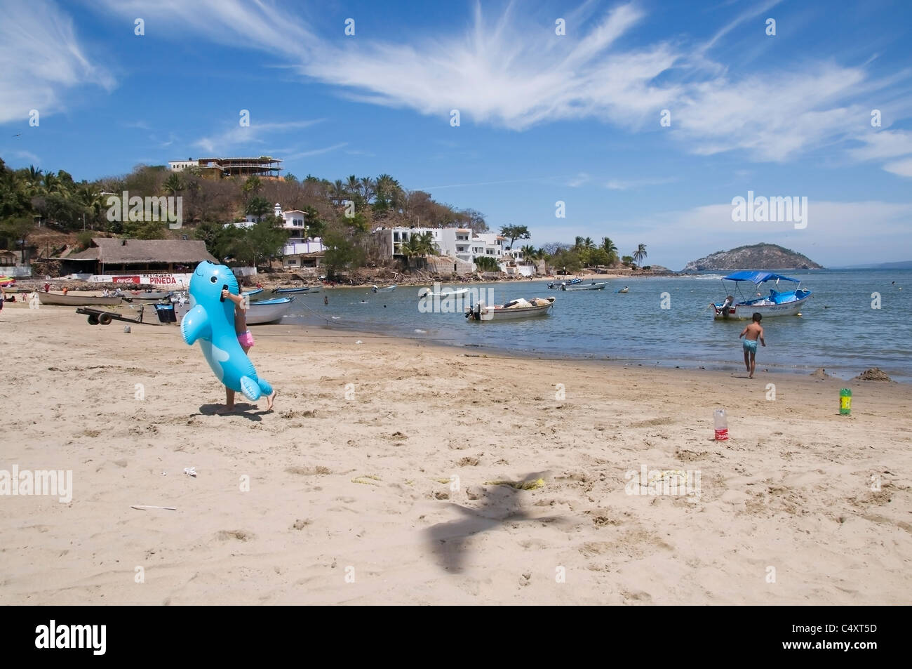 Children play and sea birds fly overhead near the calm waters of