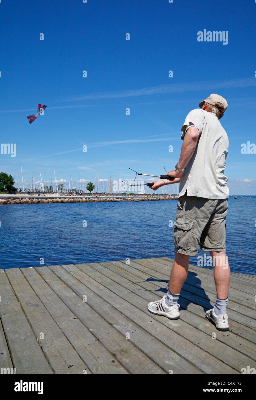 Male kite flier flying a professional quad-line kite on the beach Stock Photo