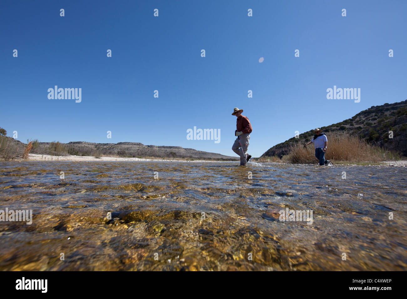 Hikers wade across shallow, springfed Independence Creek, part of a