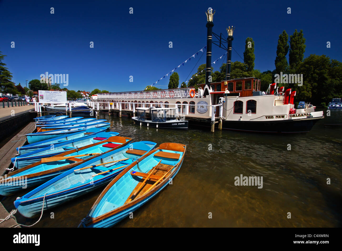 The New Orleans, a Mississippi style paddle riverboat and blue rowing boats on the River Thames at Henley-on-Thames, Oxfordshire Stock Photo