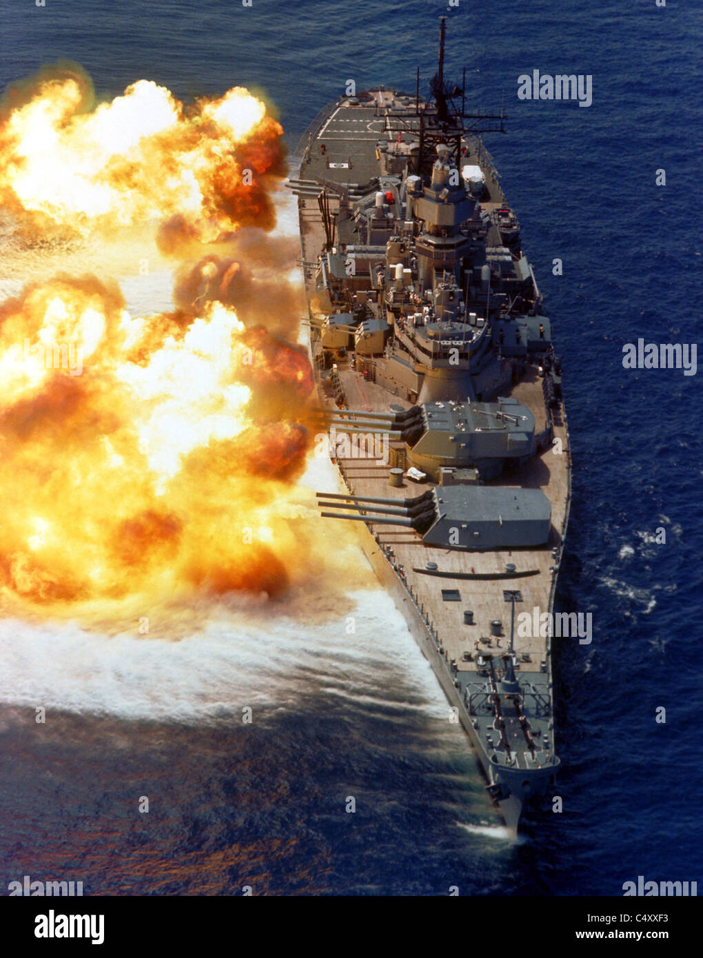USS IOWA firing its Mark 7 16-inch/50-caliber guns off the starboard side during a fire power demonstration Stock Photo