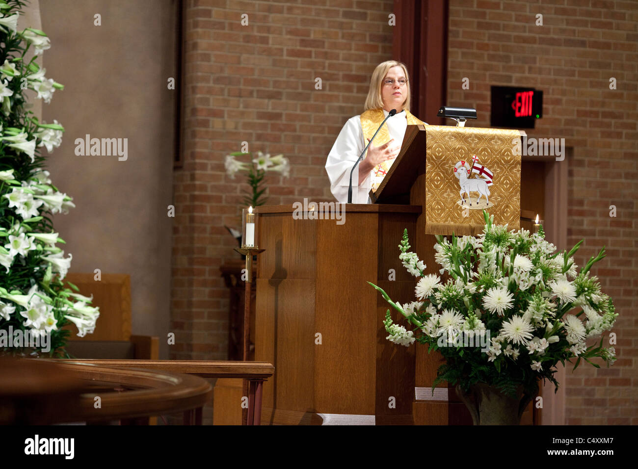 Anglo female Lutheran minister gives sermon from pulpit in the chancel