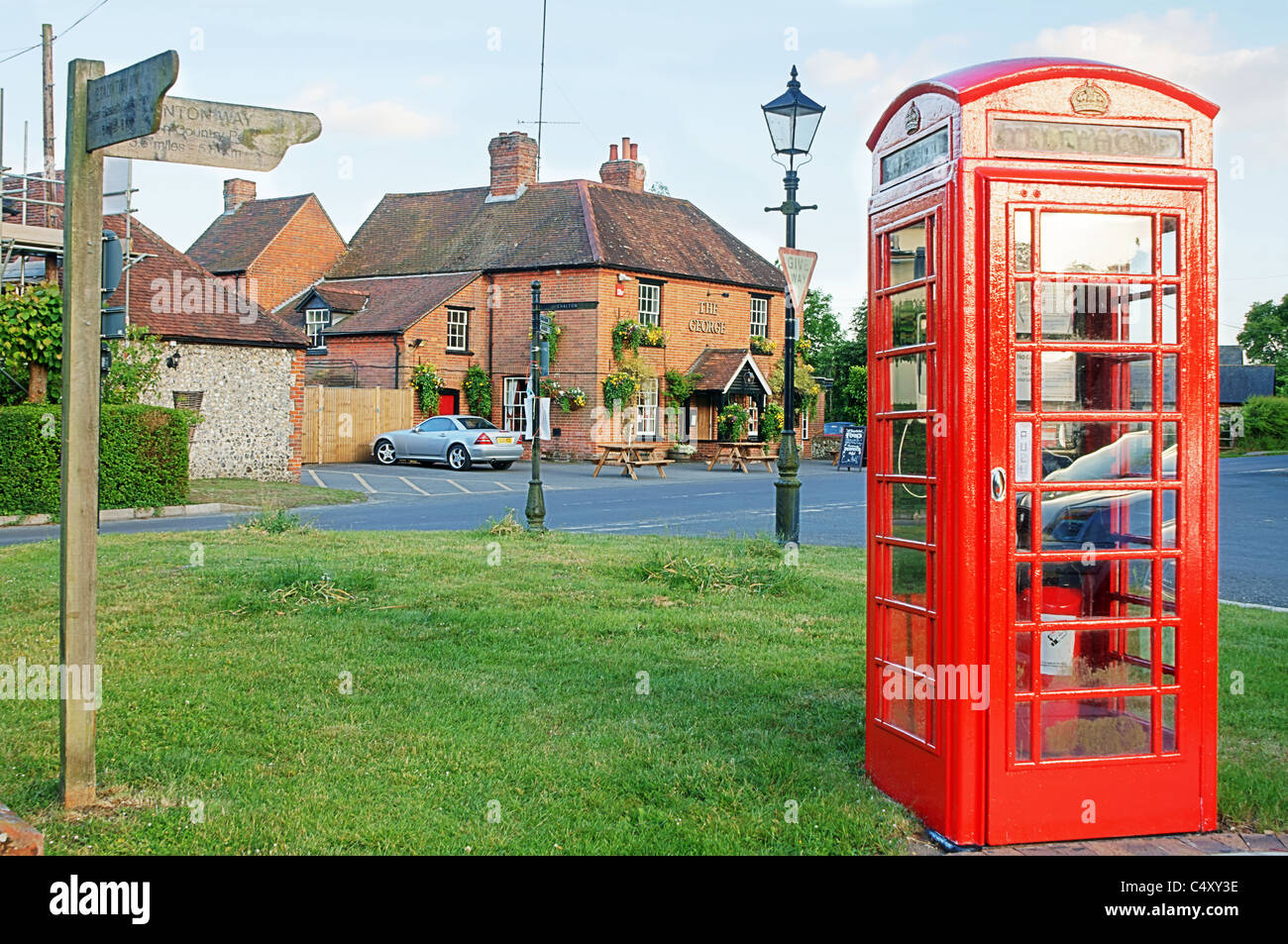 The George Inn at Finchdean, Hampshire, UK in the Spring of 2011 with red telephone box and signs Stock Photo