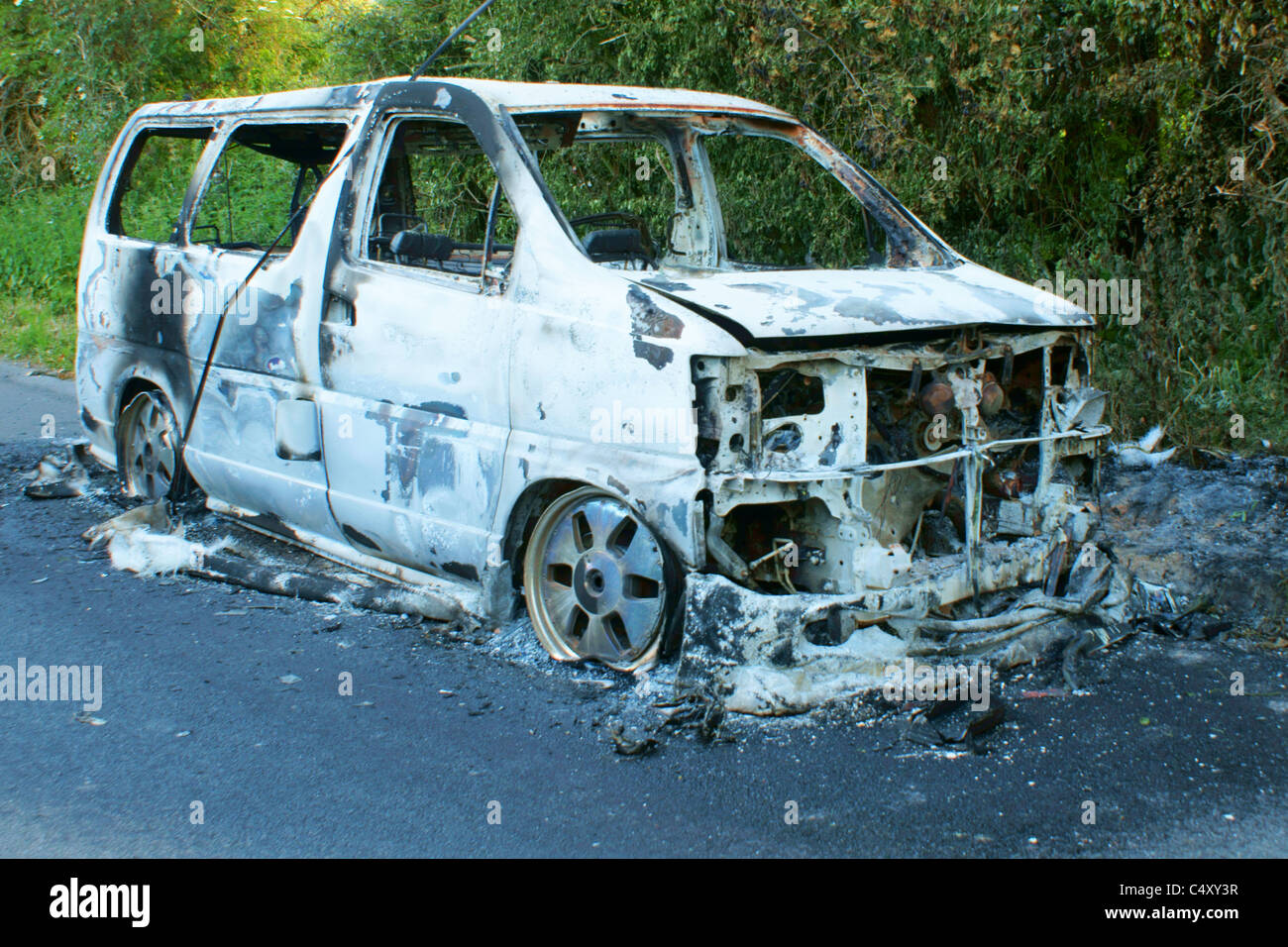 Vandalised burnt out van abandoned on the road Stock Photo Alamy