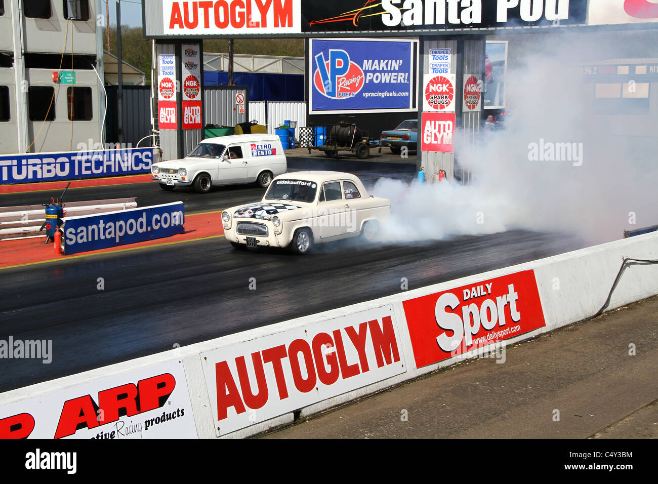 Cars warming tires on drag racing track before high speed run. Stock Photo