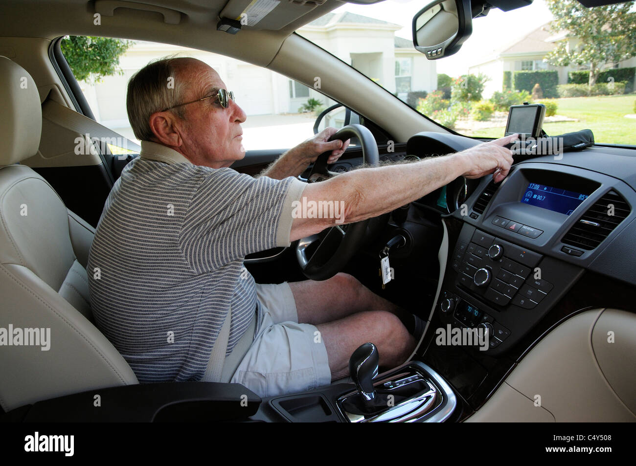 Male driver setting up Garmin satnav in holder on dashboard of an lefthand drive American car Stock Photo