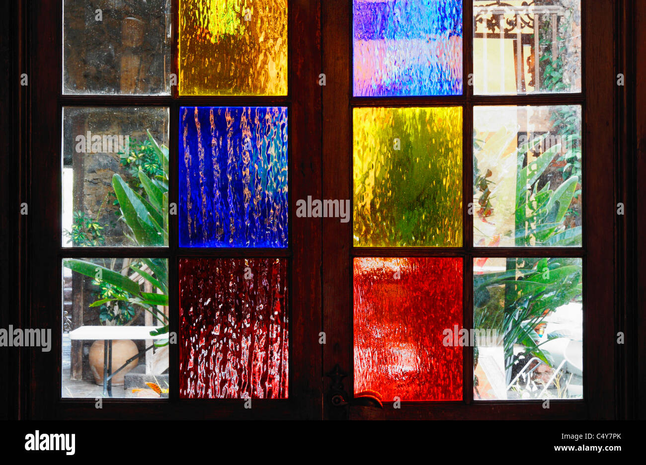 Coloured frosted glass panels on door leading to patio in house in Spain Stock Photo