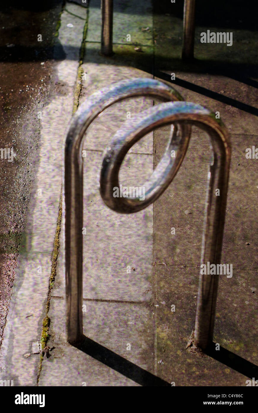 a grungy looking image of a curly metal bicycle stand Stock Photo
