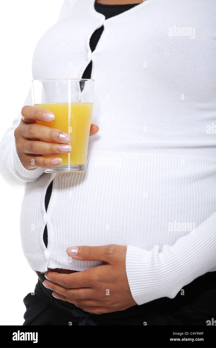 Pregnant woman holding a glass of orange juice , isolated on white ...
