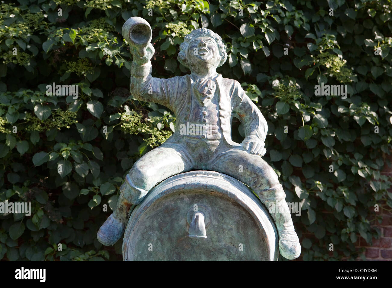 A man sitting on top of a wine barrel, sculpture in the park of Enghien, Belgium, Europe Stock Photo