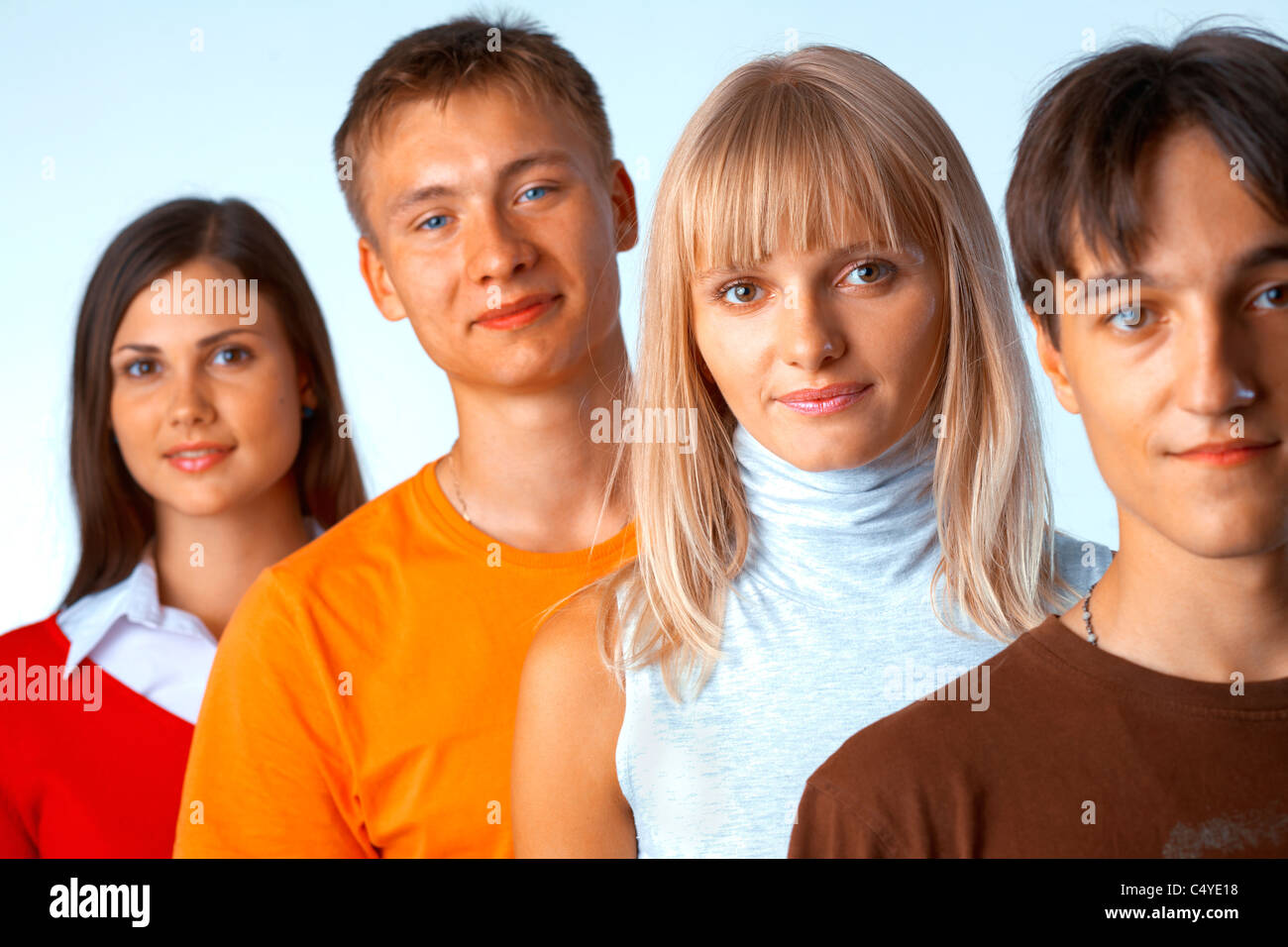 Young people standing in a row on light blue background Stock Photo - Alamy