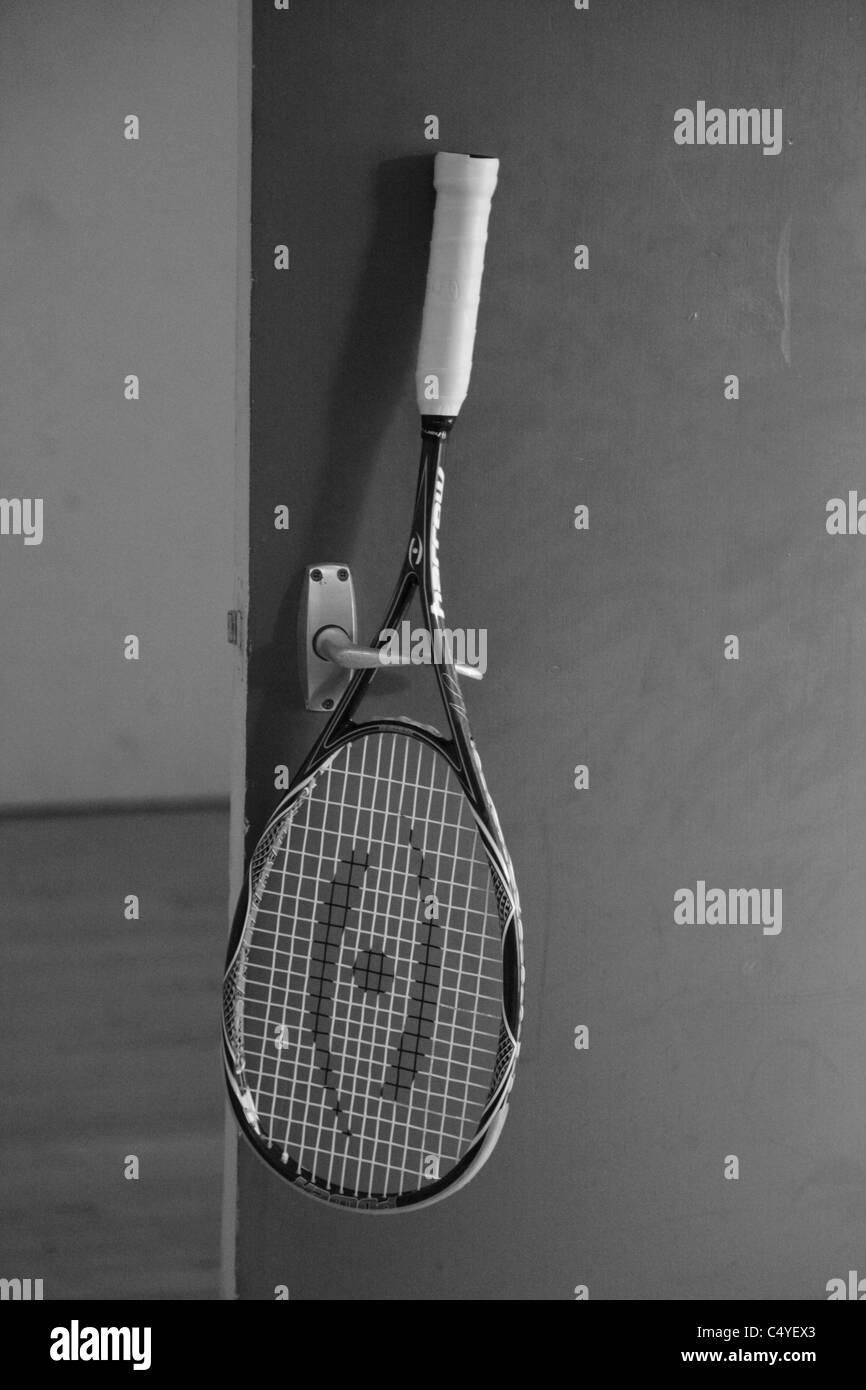 A squash racket hanging on a squash court door handle Stock Photo