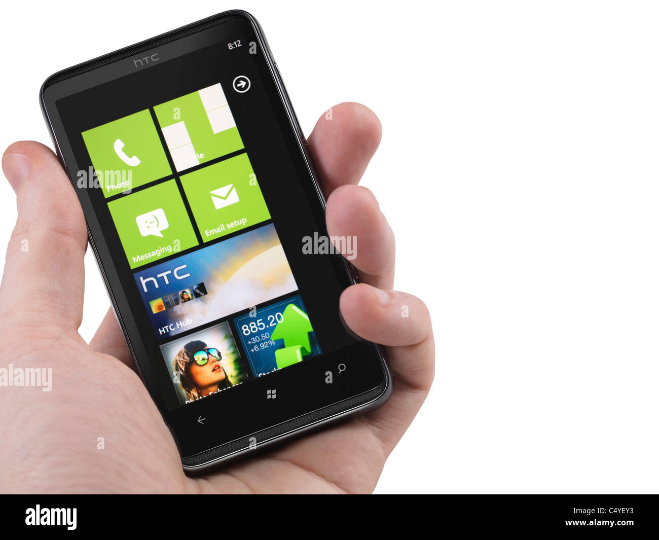 Hand with a Windows 7 phone. HTC HD7 smartphone with desktop tiles on its display isolated on white background Stock Photo