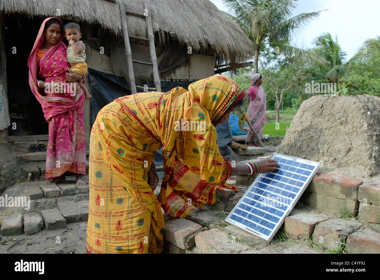 INDIA West Bengal , Sagar Island in Sundarban the delta of Ganga river , family with solar home  system, mother with infant Stock Photo