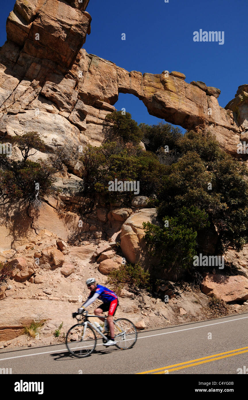 Cyclists passes an arch on Mount Lemmon, Santa Catalina Mountains, Coronado National Forest, Sonoran Desert, Tucson, Arizona. Stock Photo