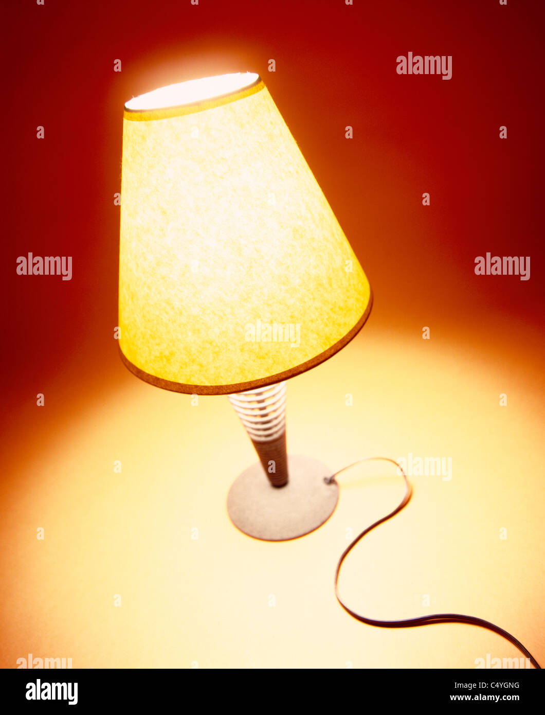 A small desk lamp with a warm light glowing Stock Photo