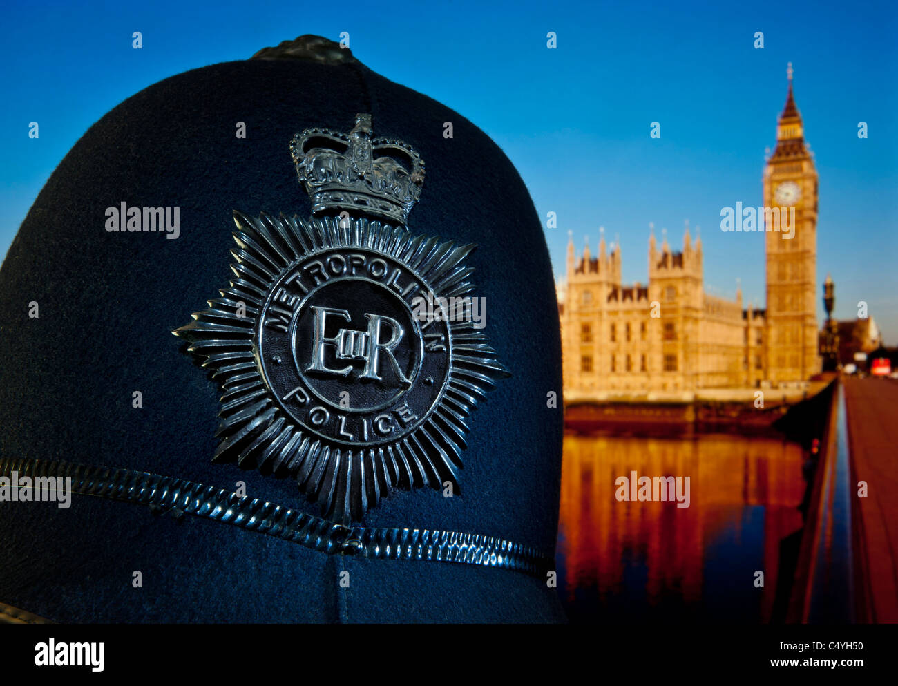 Close view on historic 1960's Metropolitan police helmet with Houses of Parliament and River Thames Westminster London UK Stock Photo