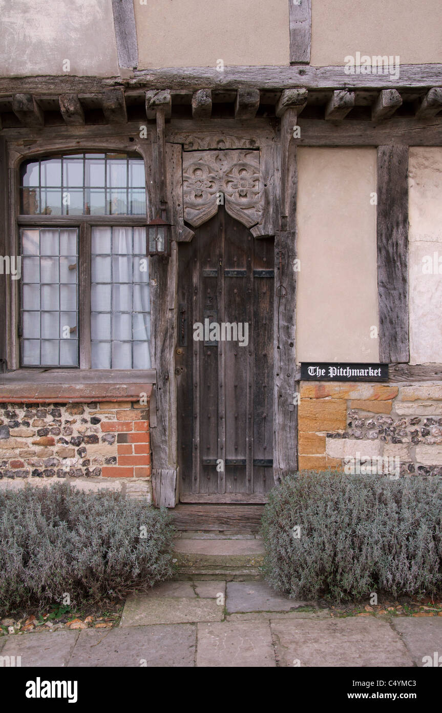 The old weather-beaten front door belonging to one of a group of ancient Tudor cottages known as the Pitchmarket at Cerne Abbas. Dorset, England, UK. Stock Photo