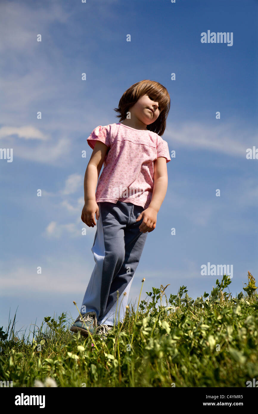 yawn of little girl on the meadow Stock Photo