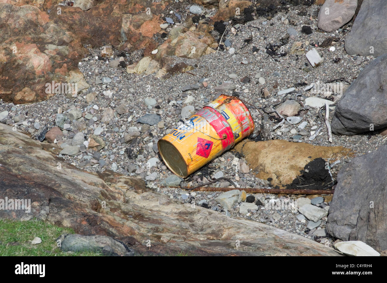 UK, Britain, Europe. Flammable liquid hazard sign on a rusty container washed up on the shore Stock Photo