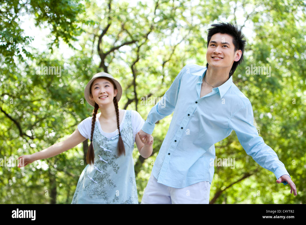Couple walking through park holding hi-res stock photography and images ...