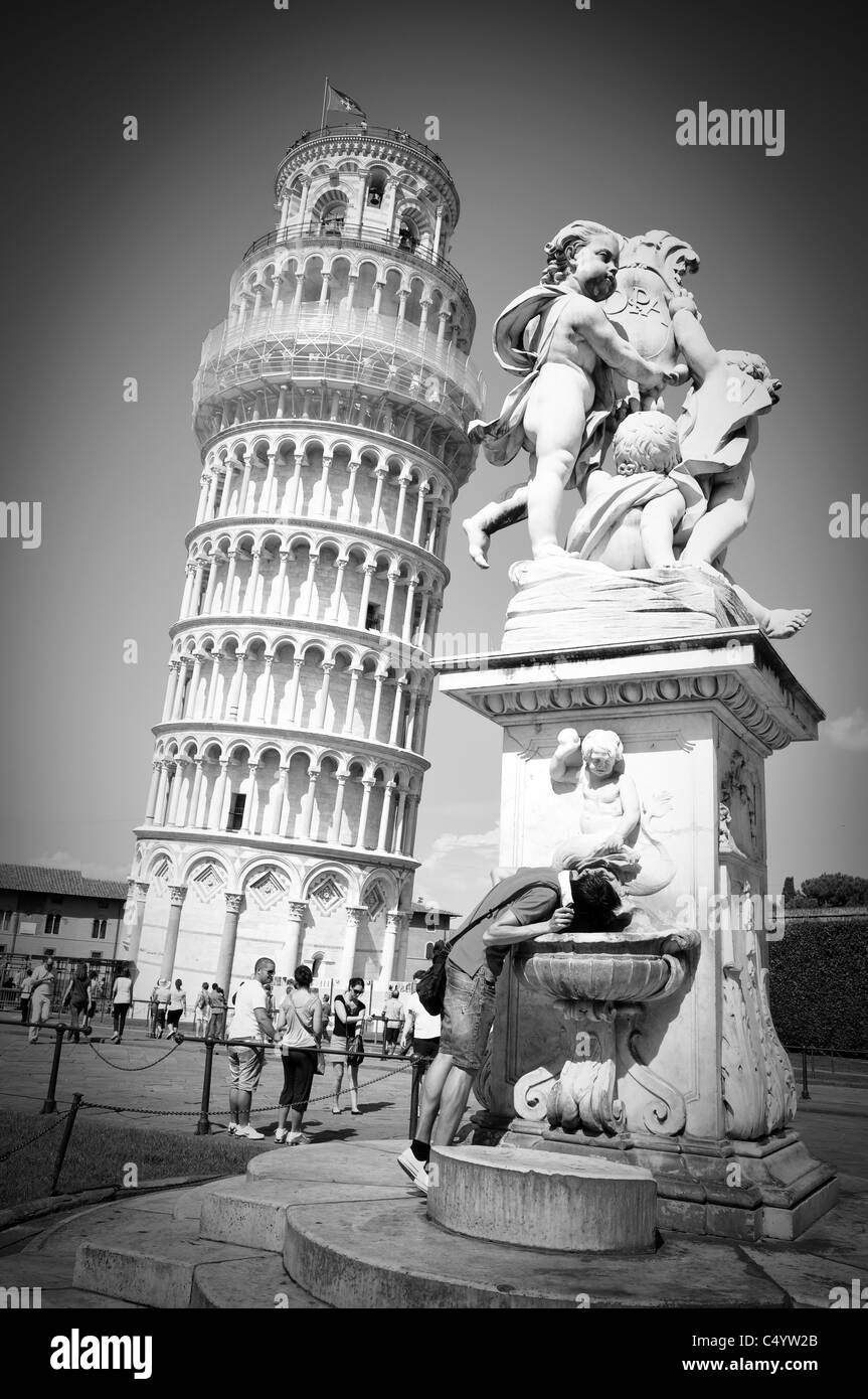 Man drinking at fountain by leaning tower of Pisa, Italy Stock Photo