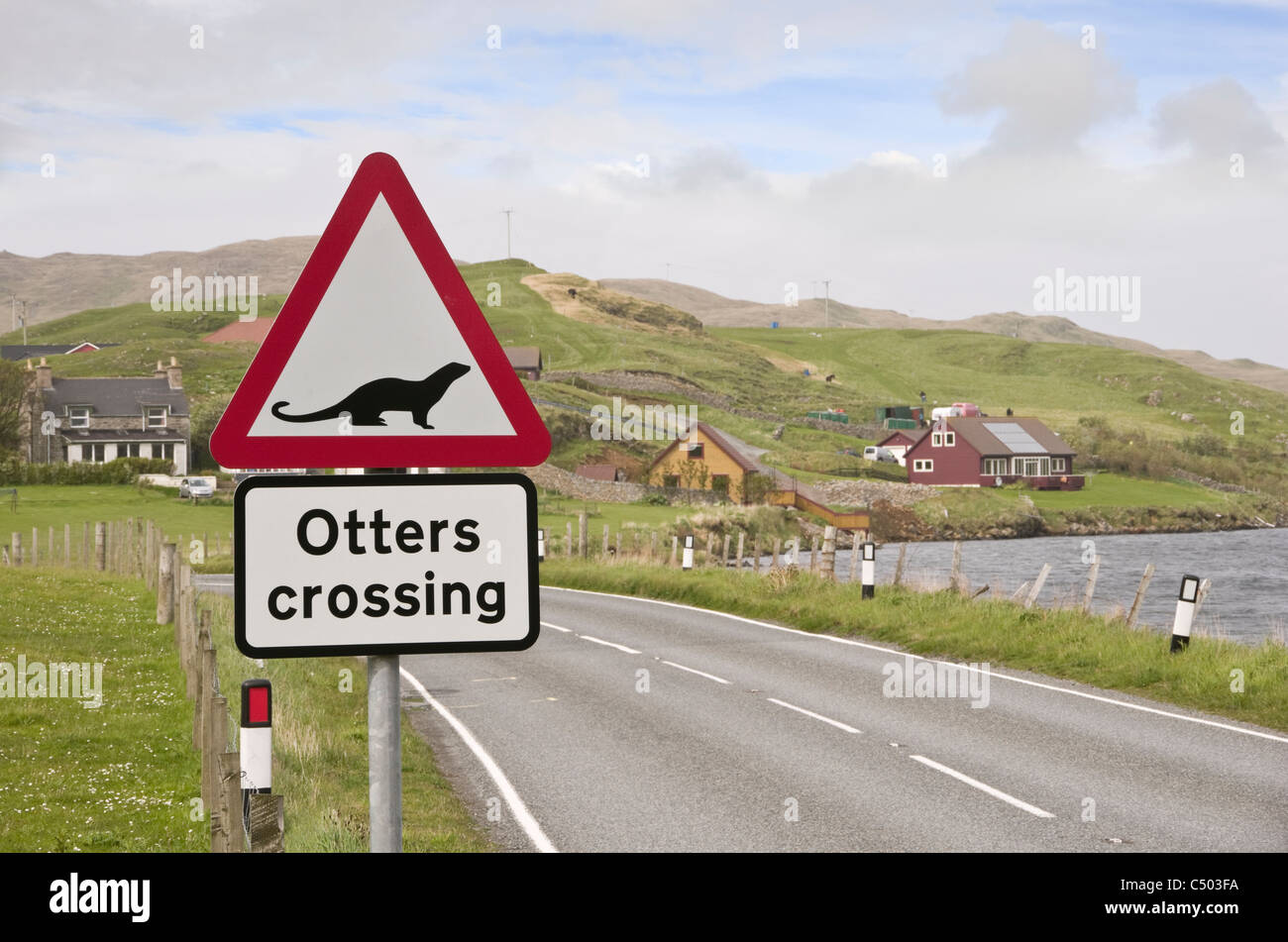 Road sign warning otters crossing near a sea loch on Scottish Shetland island coast. Whiteness, Shetland Isles, Scotland, UK, Britain Stock Photo