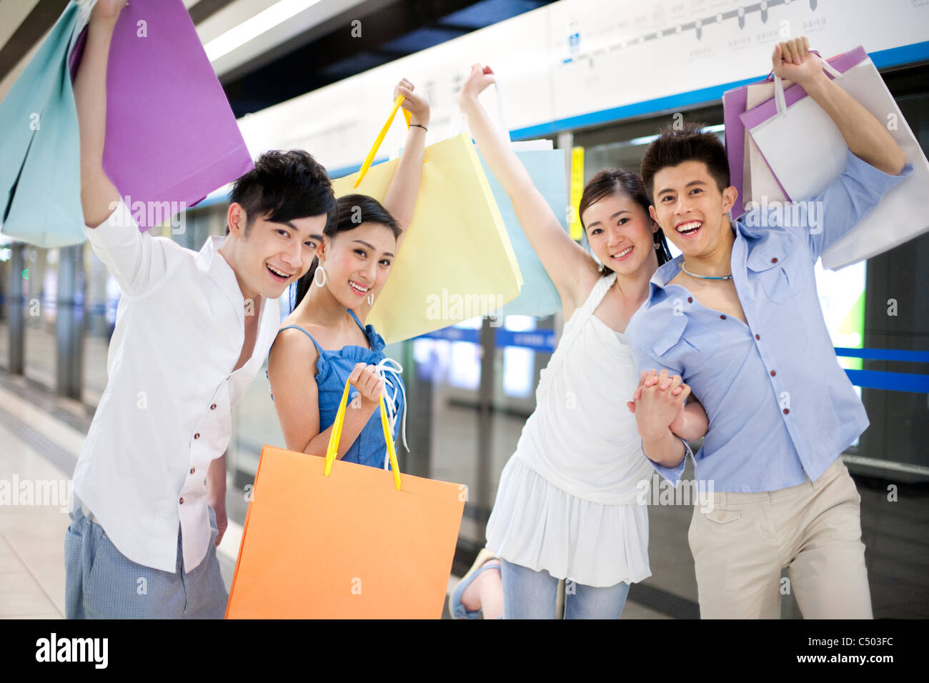 Friends Carrying Shopping Bags at the Subway Station Stock Photo