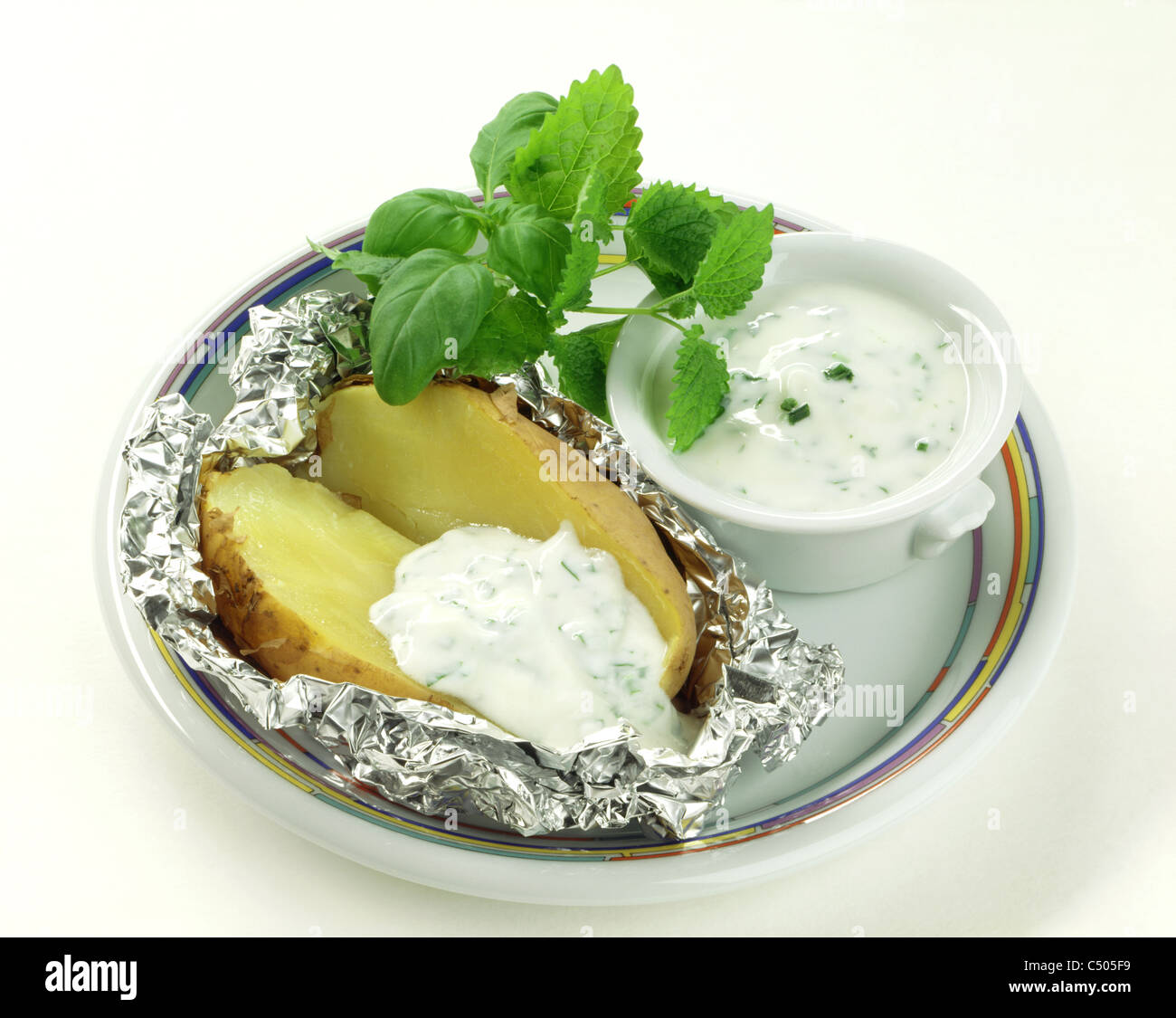 Baked potato with herbal yogurt Stock Photo Alamy