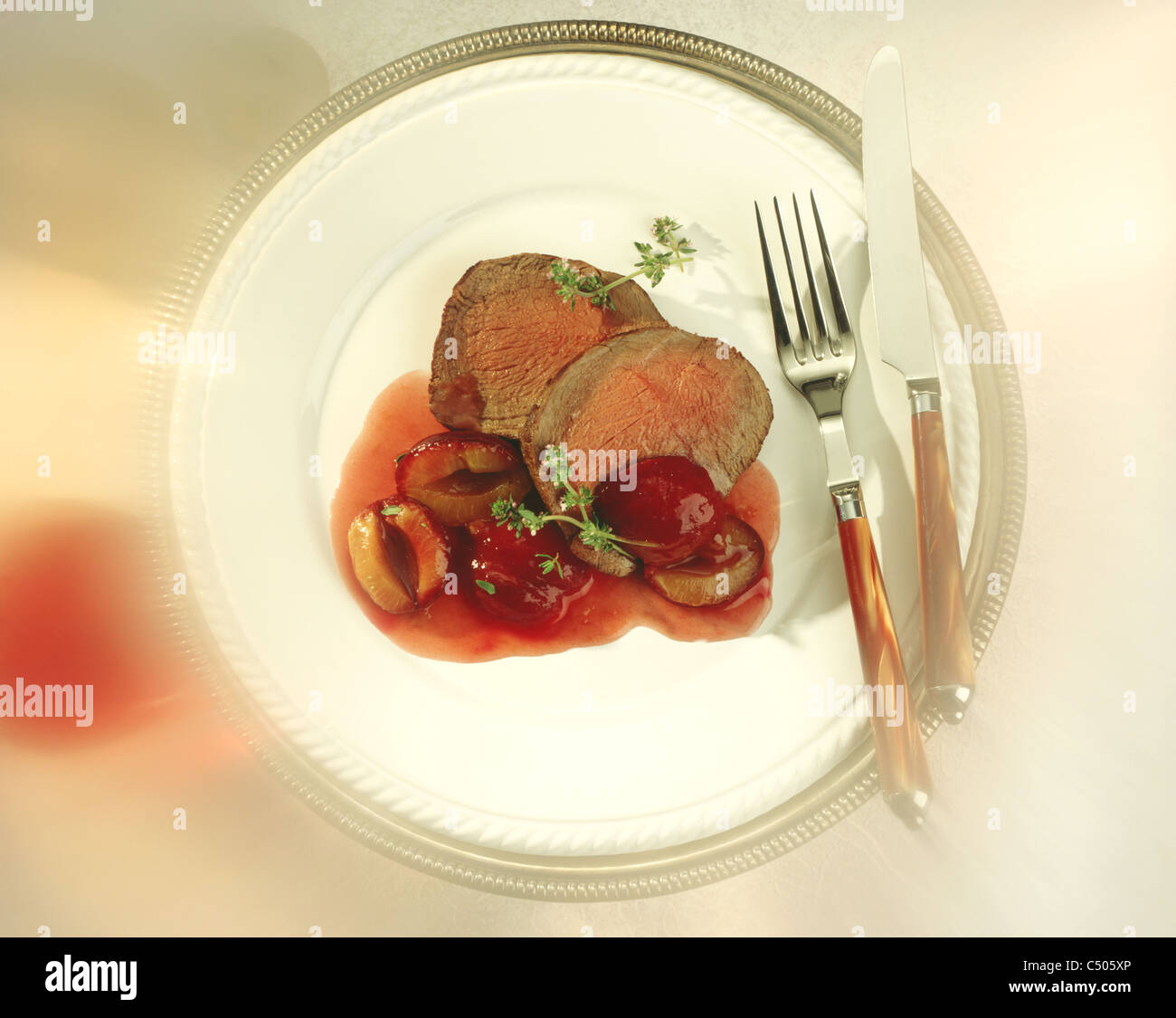 Fillet of venison back with plums in red wine sauce Stock Photo Alamy