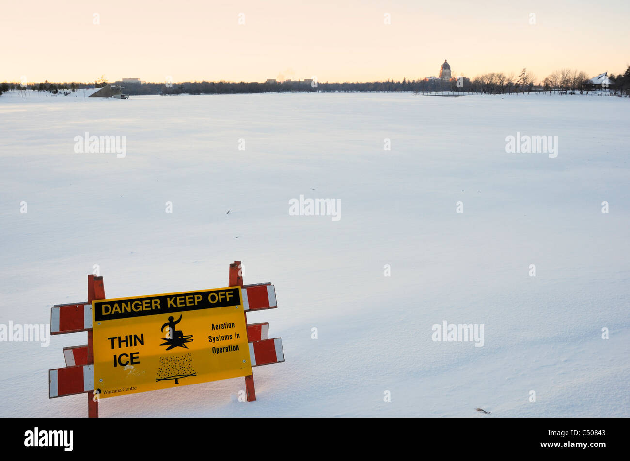 Thin ice warning signs around Wascanna Lake Regina Saskatchewan, Canada. Stock Photo