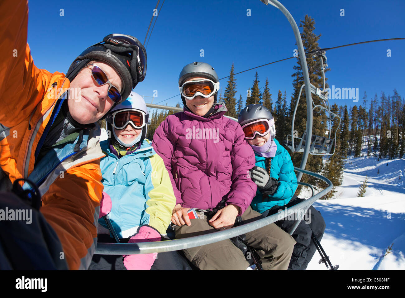 Family riding ski lift together Stock Photo