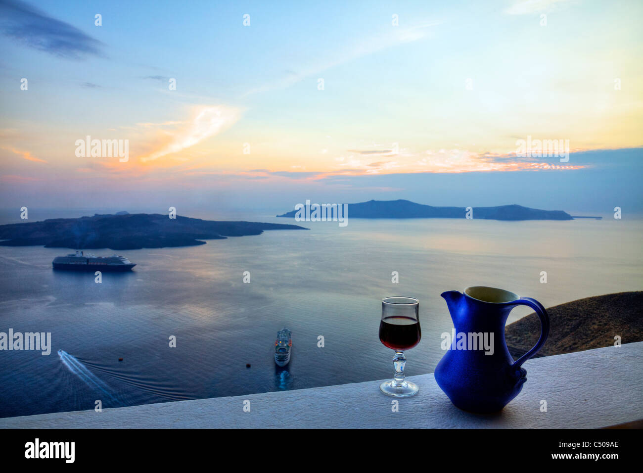 Santorini typical iconic Greek Island sunset drink of retsina wine jug & glass caldera cruise ship thira Stock Photo