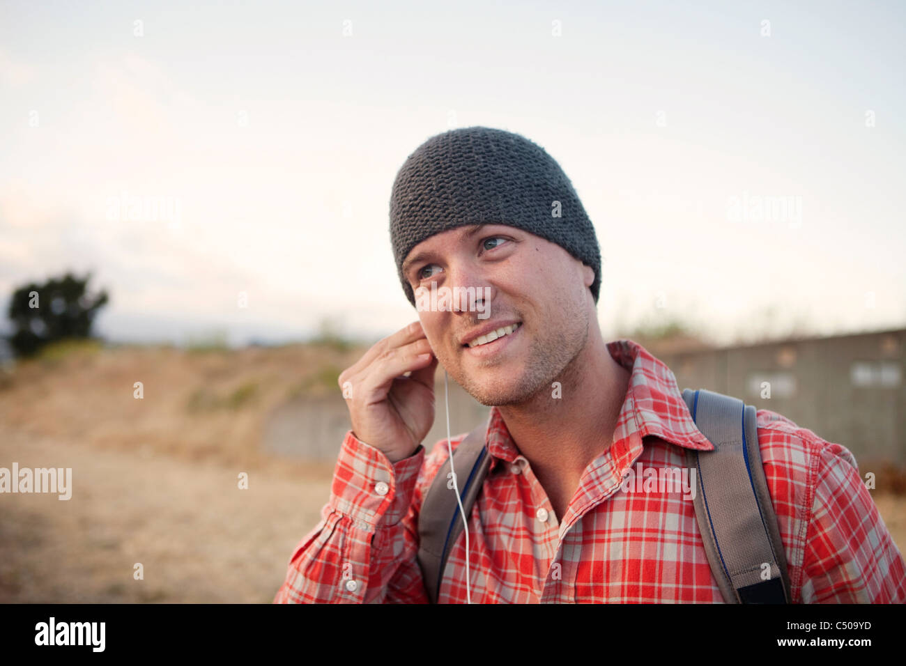 Man putting in earbuds in remote area Stock Photo