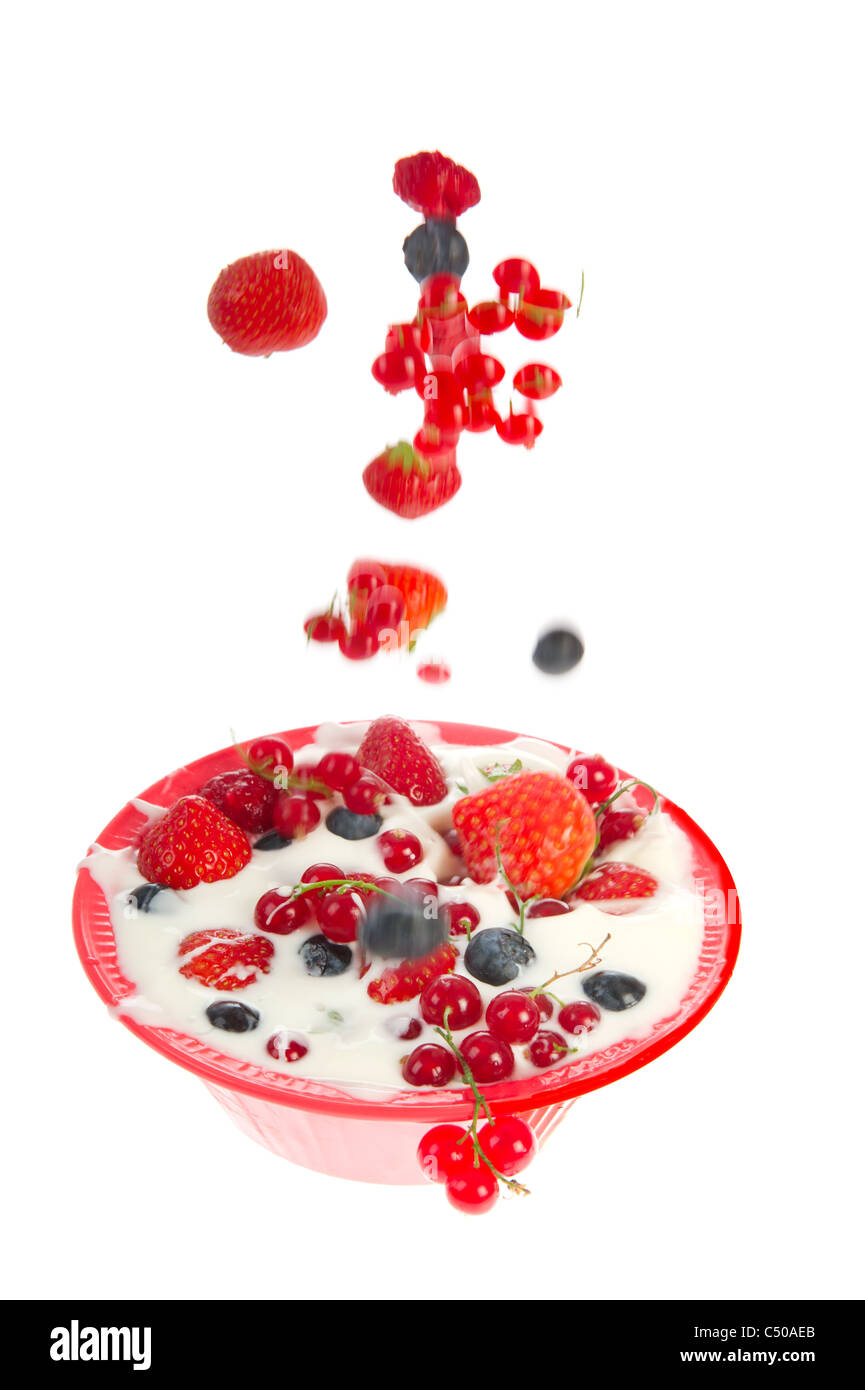 Bowl yogurt with various fresh fruit isolated over white background Stock Photo
