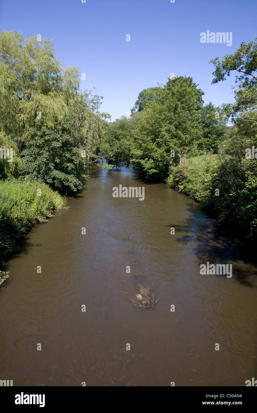 Silt-laden water rushing over a weir on the River Stour Blandford Dorset  England UK Stock Photo - Alamy