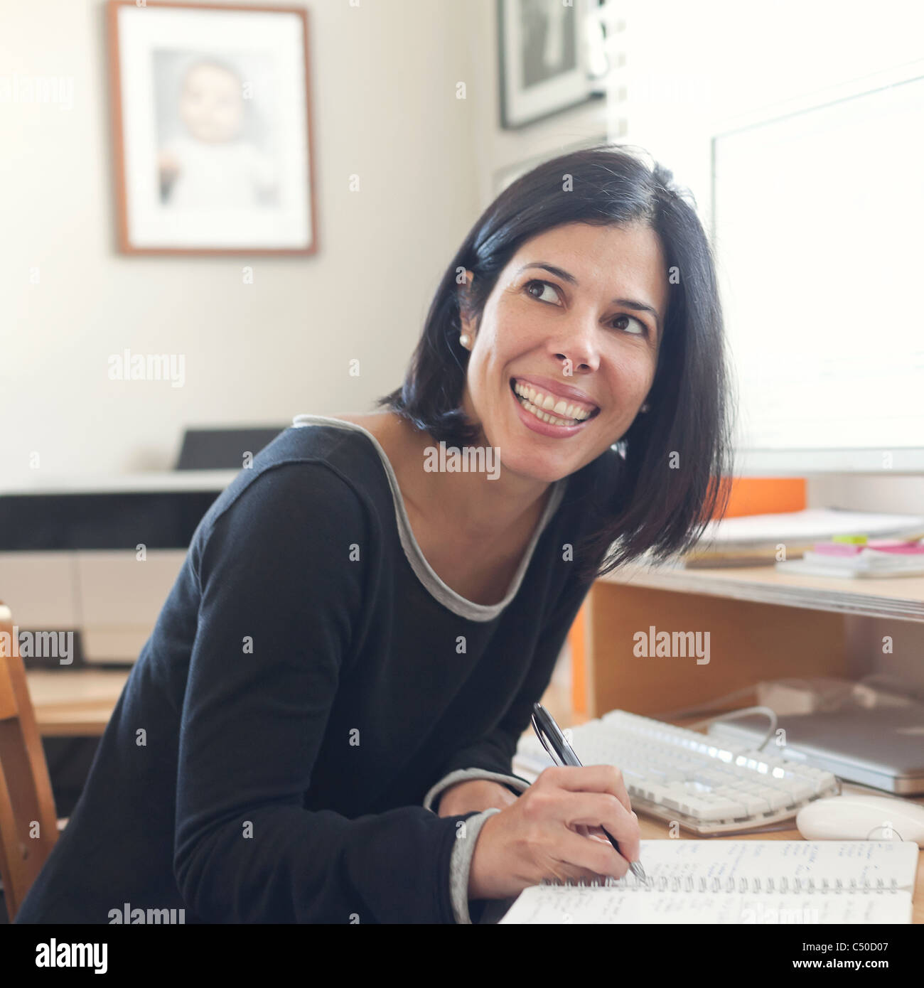 Hispanic woman working in home office Stock Photo