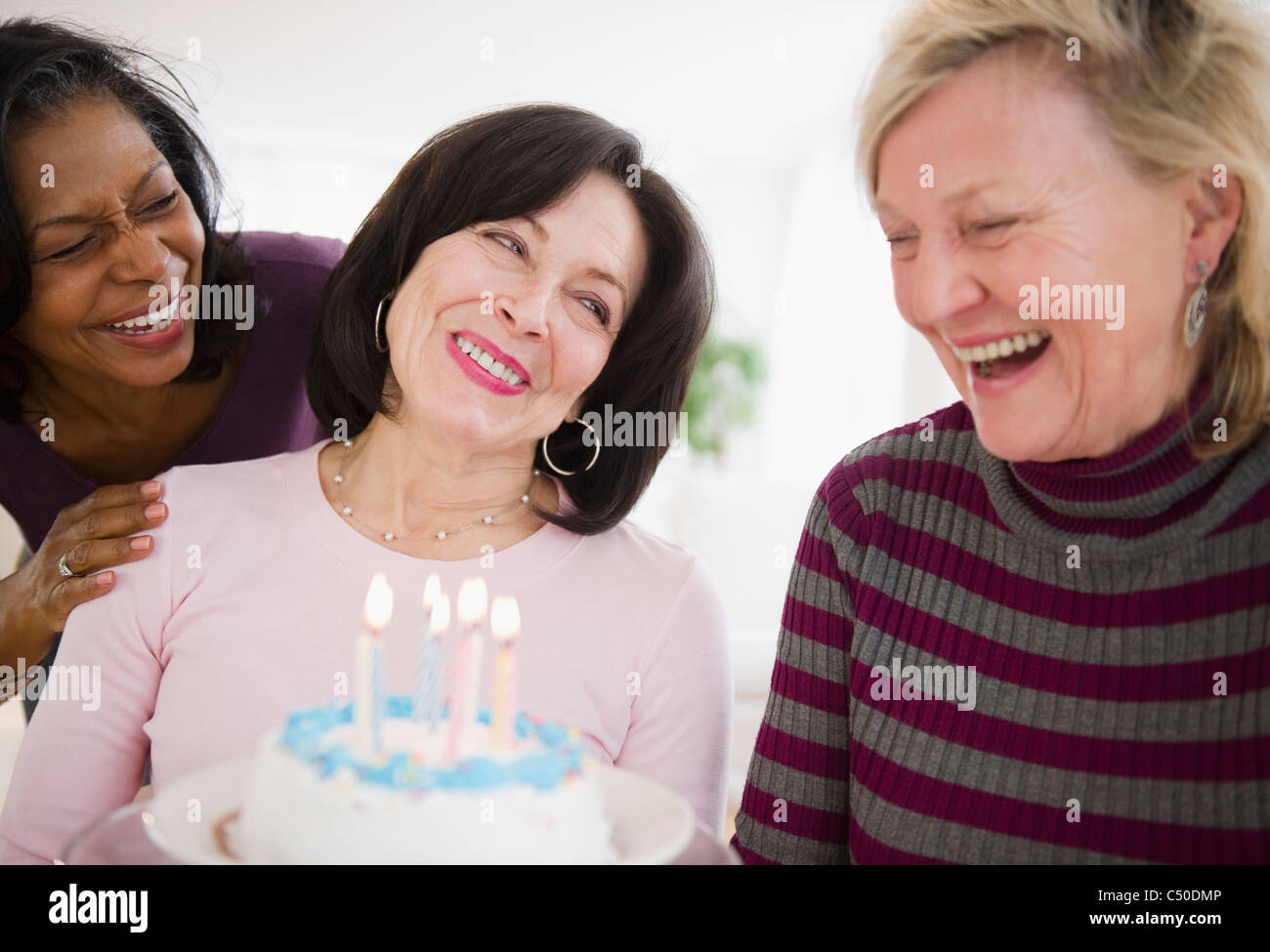 Women surprising friend with birthday cake Stock Photo