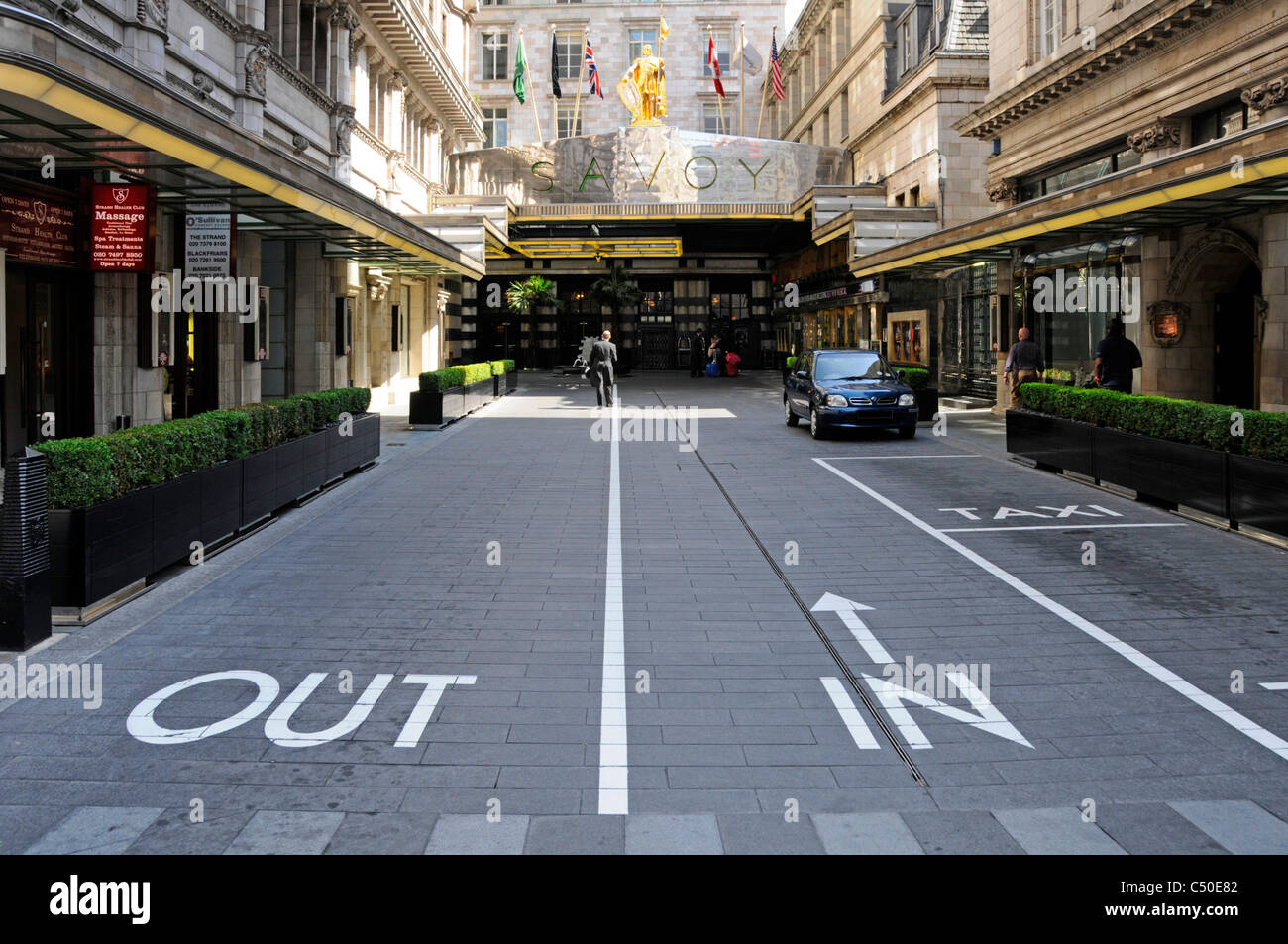 London street scene Savoy Hotel unusual public entrance road driving in on right hand side legal & permitted out & in signs Savoy Court England UK Stock Photo