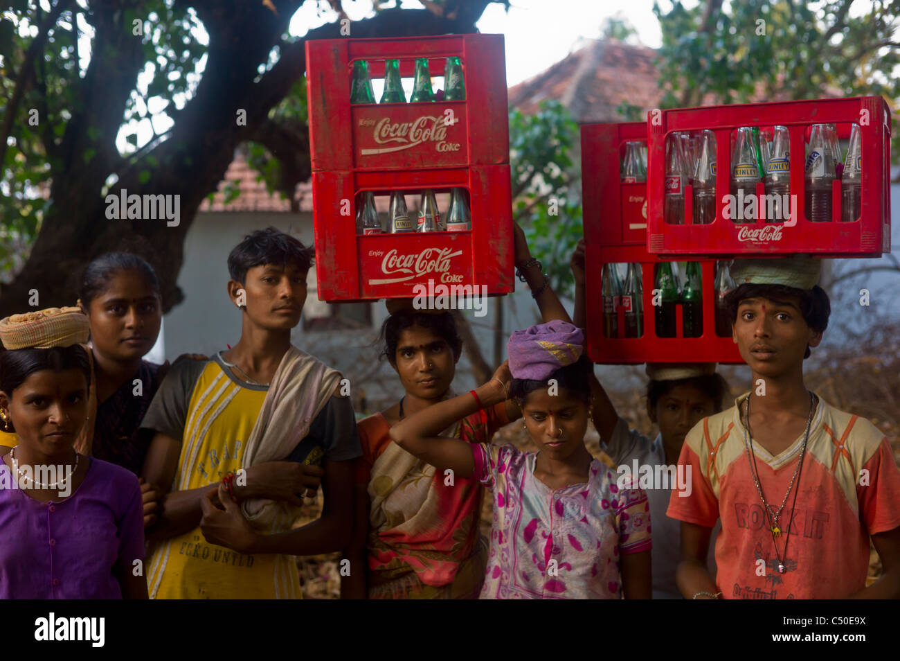 Indian youth carrying coca cola boxes on their heads, Anjuna, Goa, India Stock Photo